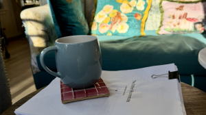 Blue coffee mug on top of manuscripts